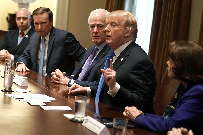 U.S. President Donald Trump (4th L) speaks as (L-R) Rep. Brian Mast (R-FL), Sen. Christopher Murphy (D-CT), Senate Majority Whip Sen. John Cornyn (R-TX) and Sen. Dianne Feinstein (D-CA) listen during a meeting with bipartisan members of the Congress at the Cabinet Room of the White House February 28, 2018 in Washington, DC.